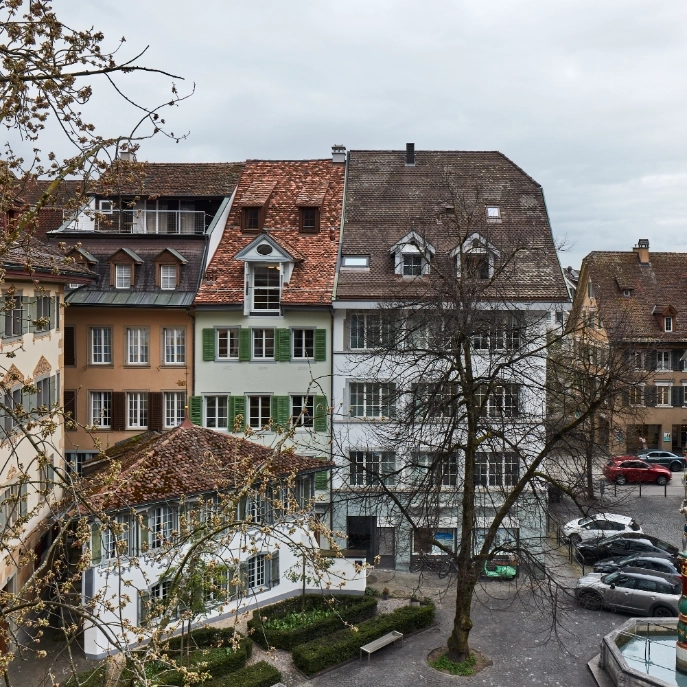 Drei Häuser an der Neugasse im Vordergrund der Hirschenplatz mit dem Baum und dem kleinen Haus der Münz